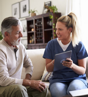 Caregiver consulting with elderly man