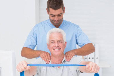 Man helping old man do physical exercises